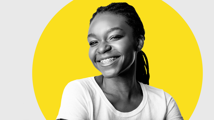 Black-and-white portrait of a woman with braces. There is an added graphic yellow circle behind her.
