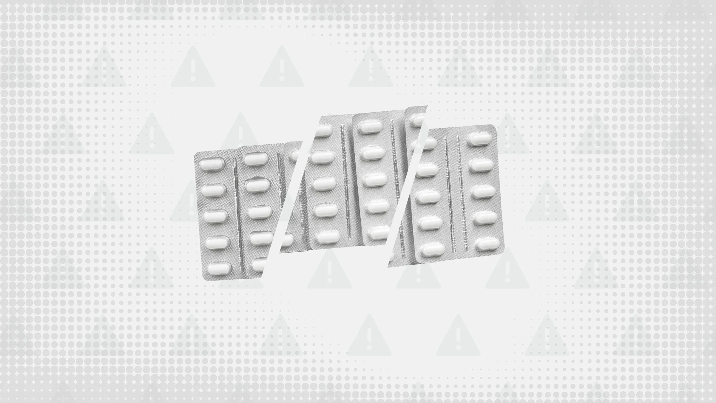 Gray background with texture and warning sign pattern. In the center are three silver blister packs of oblong white pills cut into thirds. 