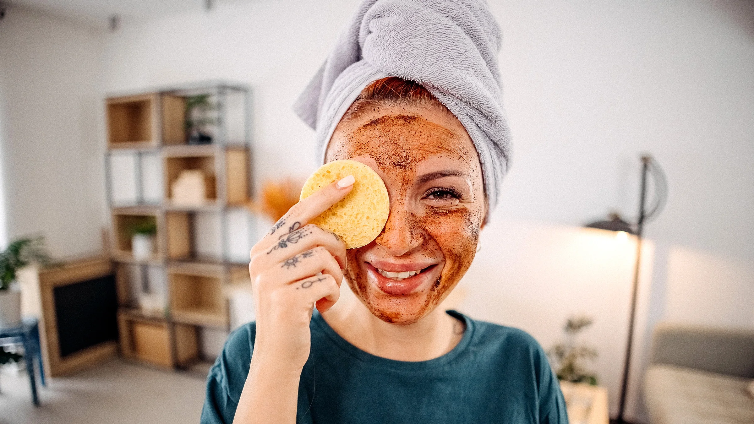 Woman applies a scrub mask on her face.