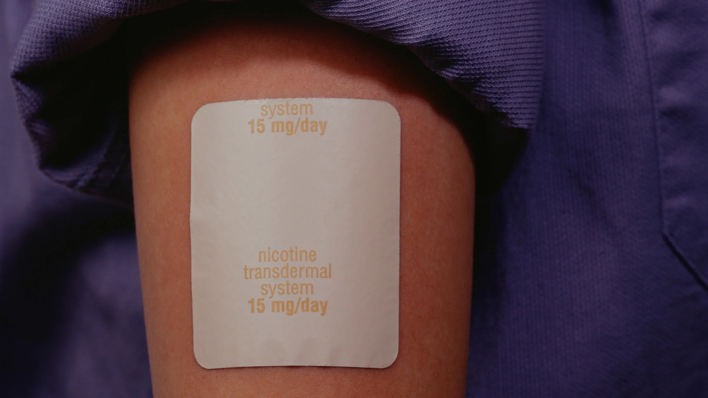 Close-up of a nicotine patch on an arm.
