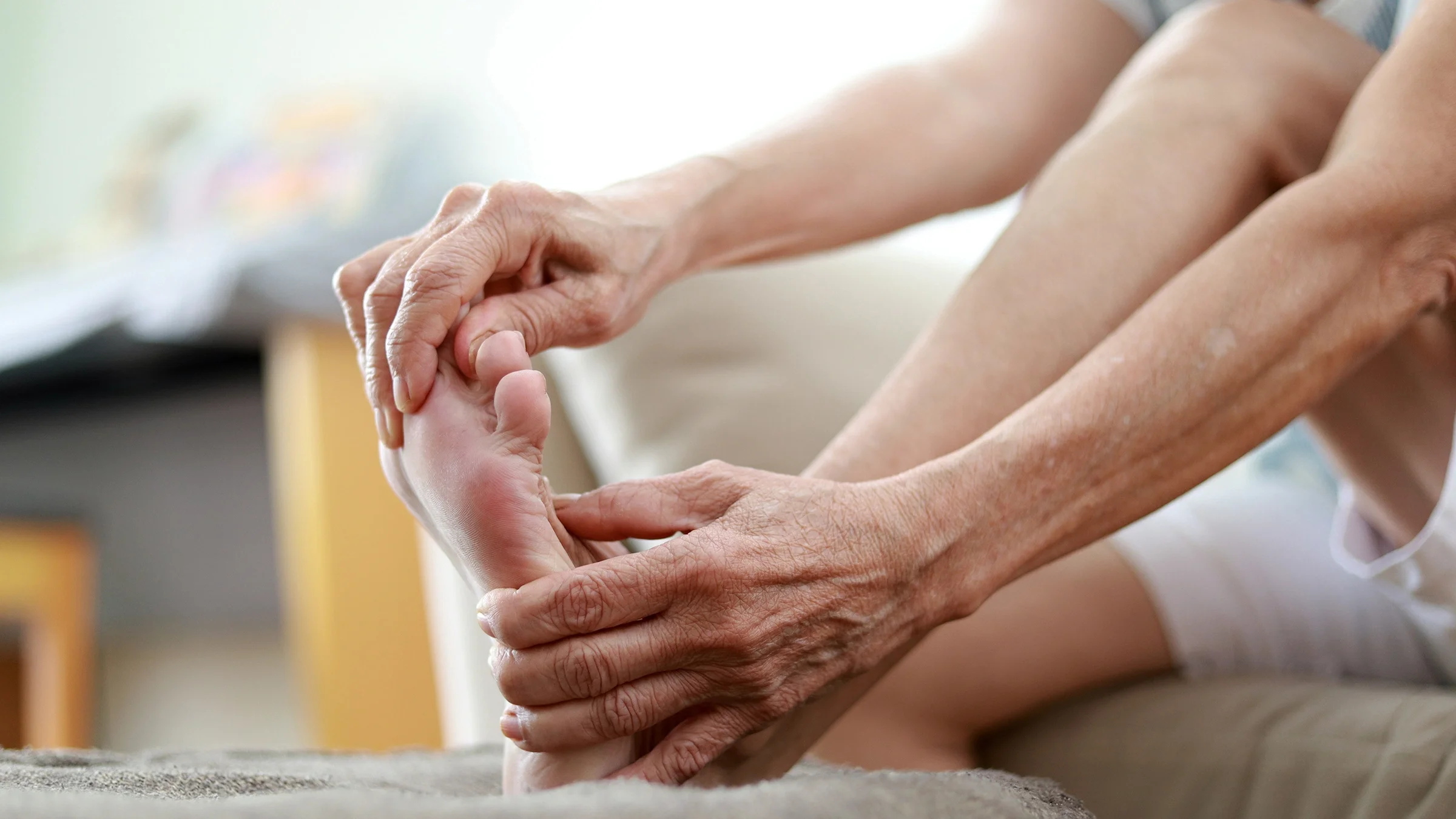 Close-up of older woman massaging toes.