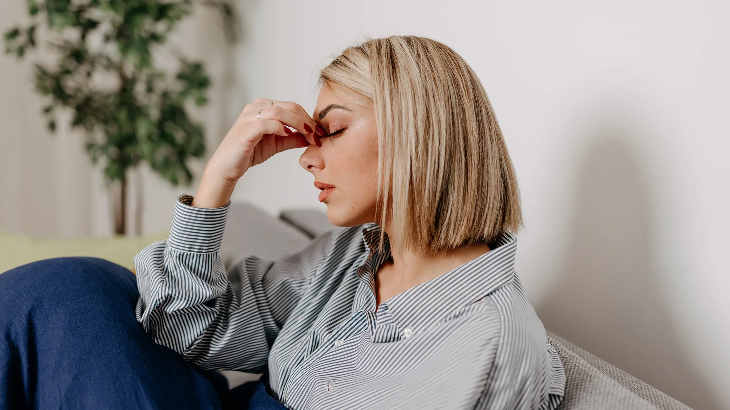 A woman is holding her face like she has sinus pain.
