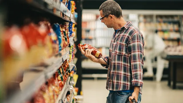 Diet Nutrition: man buying pasta in supermarket 1973410818