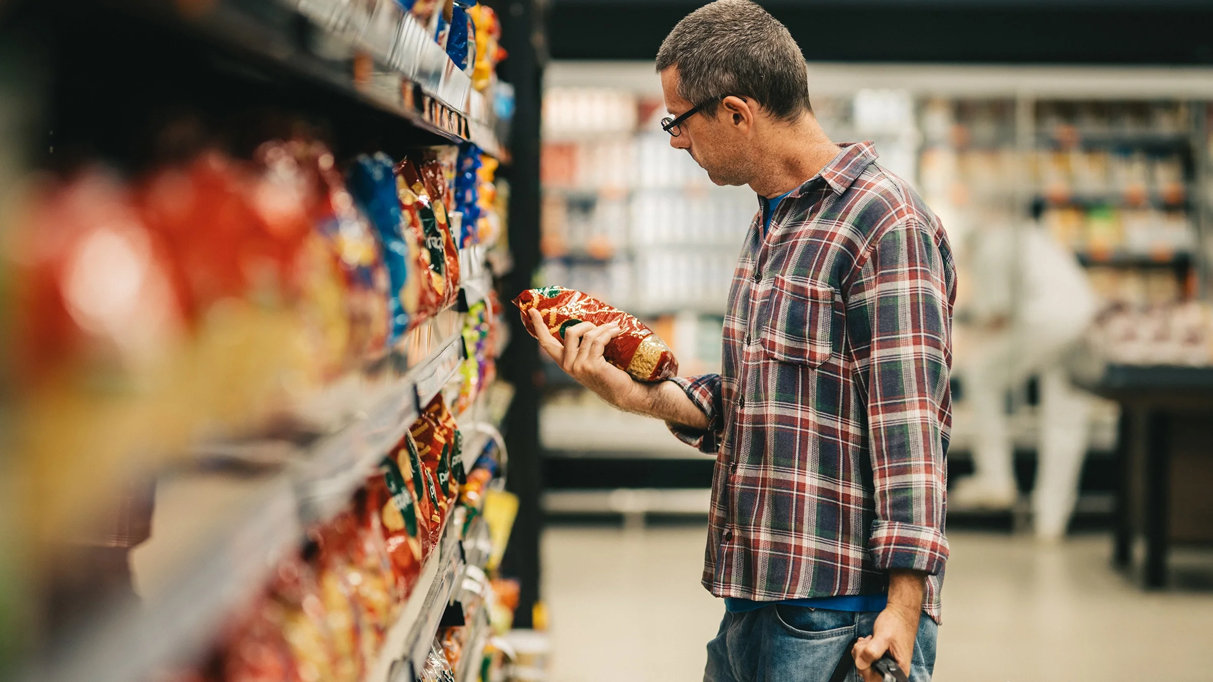 A man shops for pasta at the supermarket.
