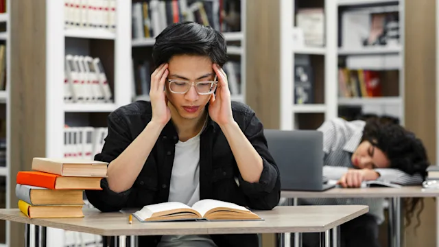 Substance use disorder: Perfectionism: tired late-night studying college library 1252691219