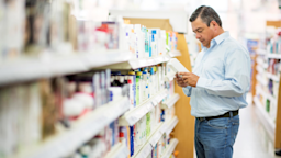 Man reading back of medicine packaging at a pharmacy.
andresr/E+ via Getty Images