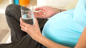 Health: Parenthood-Pregnancy: closeup pregnant woman taking pill-618554692