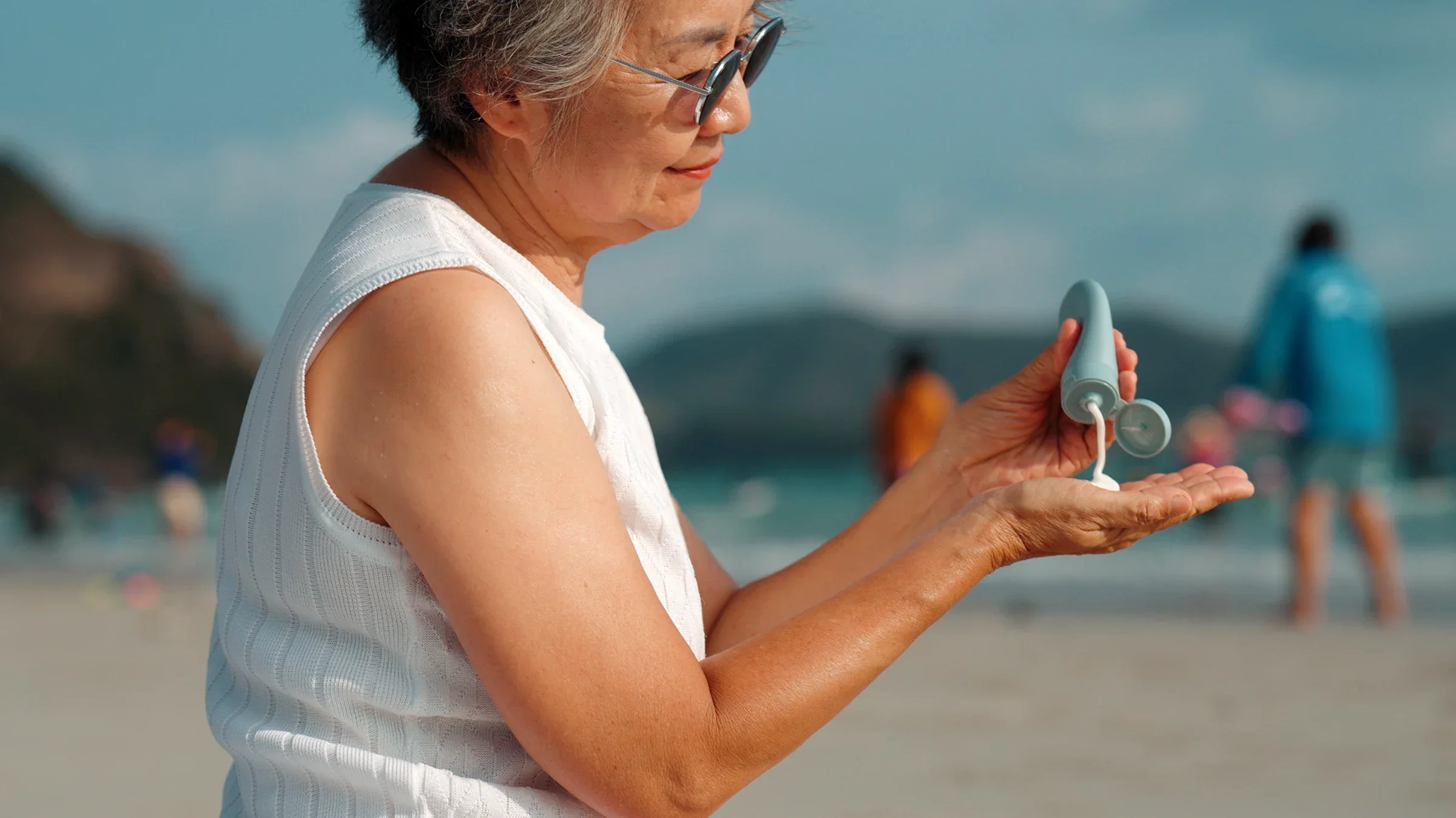 A woman applies sunscreen while at the beach.
tkpond/iStock via Getty Images Plus