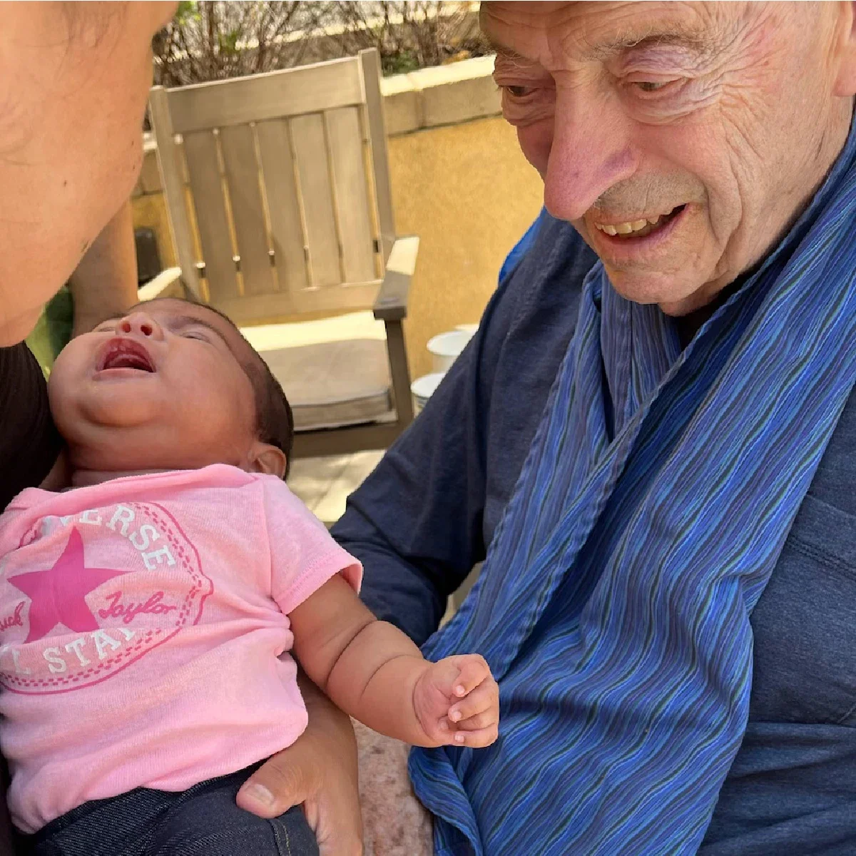 David Rothman is pictured smiling next to a baby whose family visited him in his care facility.