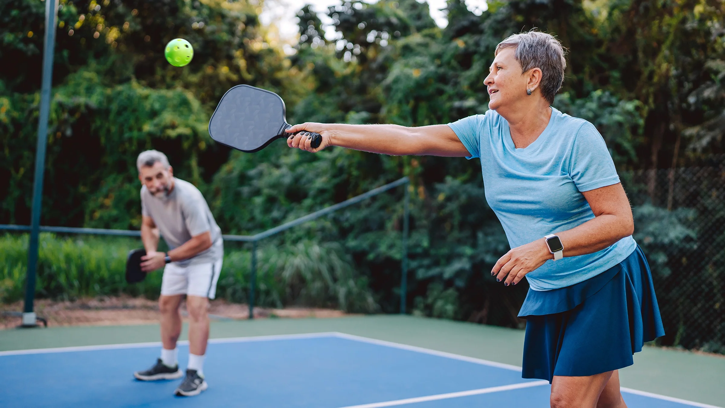 Senior couple playing pickleball