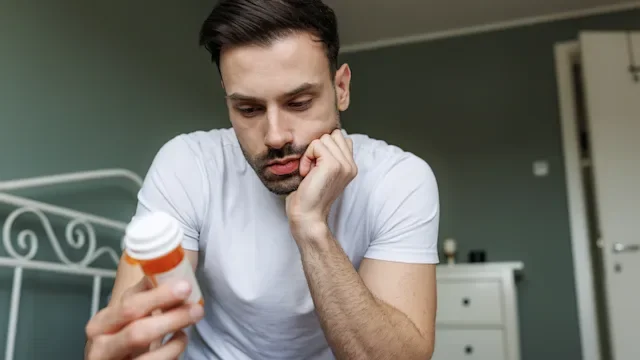 Adderall: man reading Rx label 2208458170