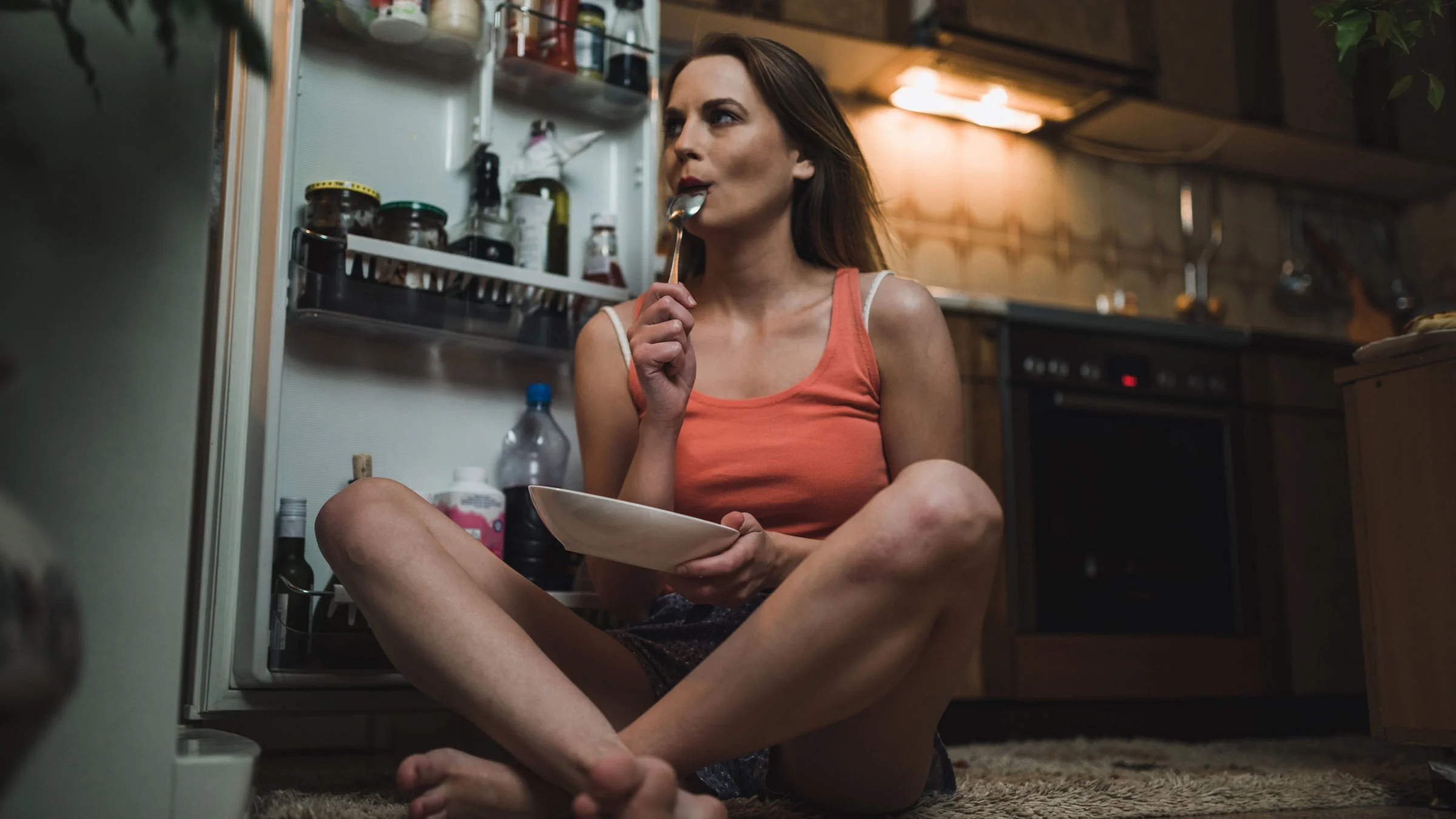 A woman is eating a midnight snack.