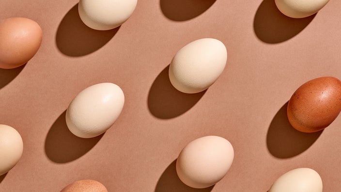 Various eggs creating a pattern on a tan background.