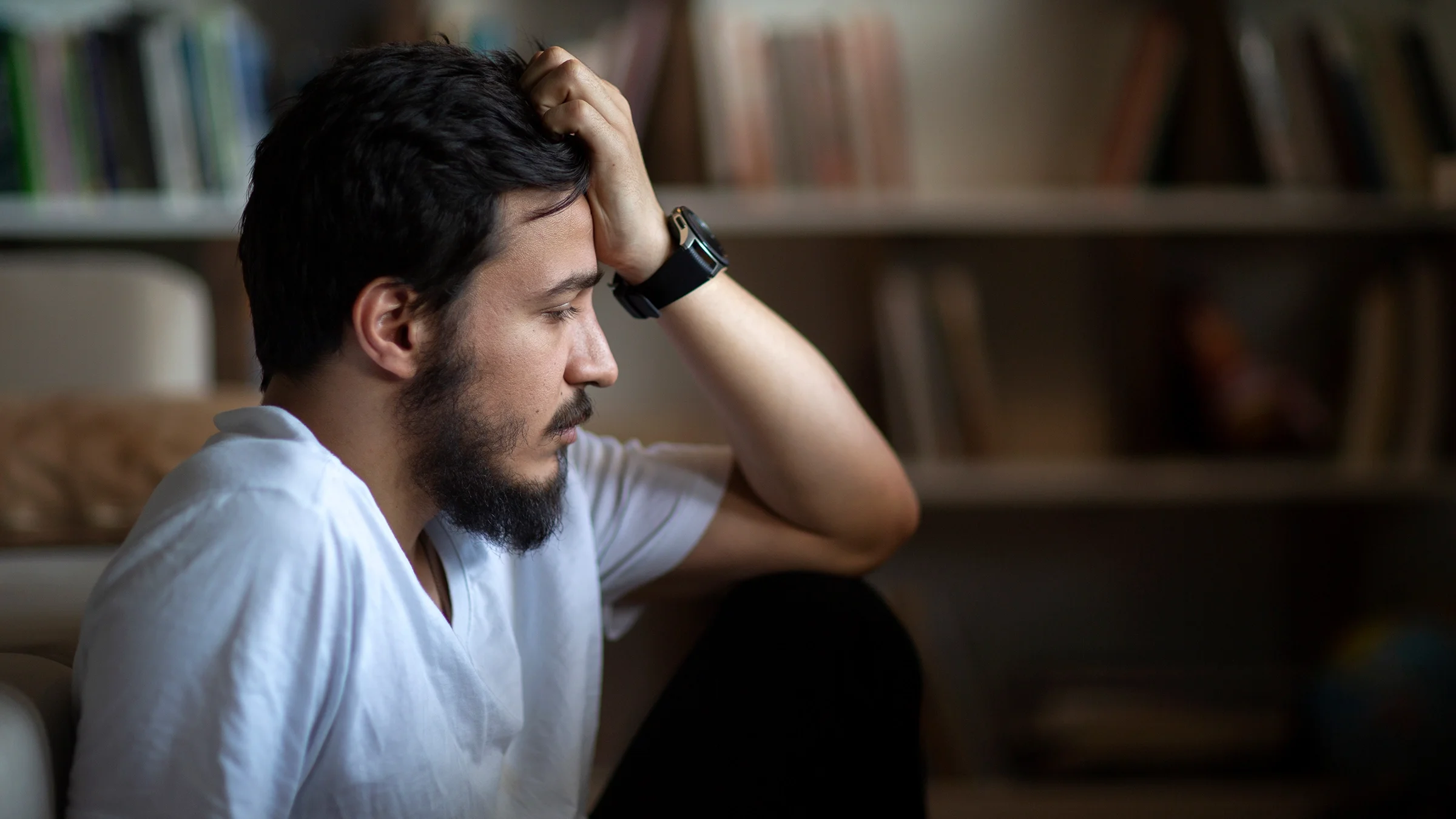 Man sitting on the floor with a sad expression.