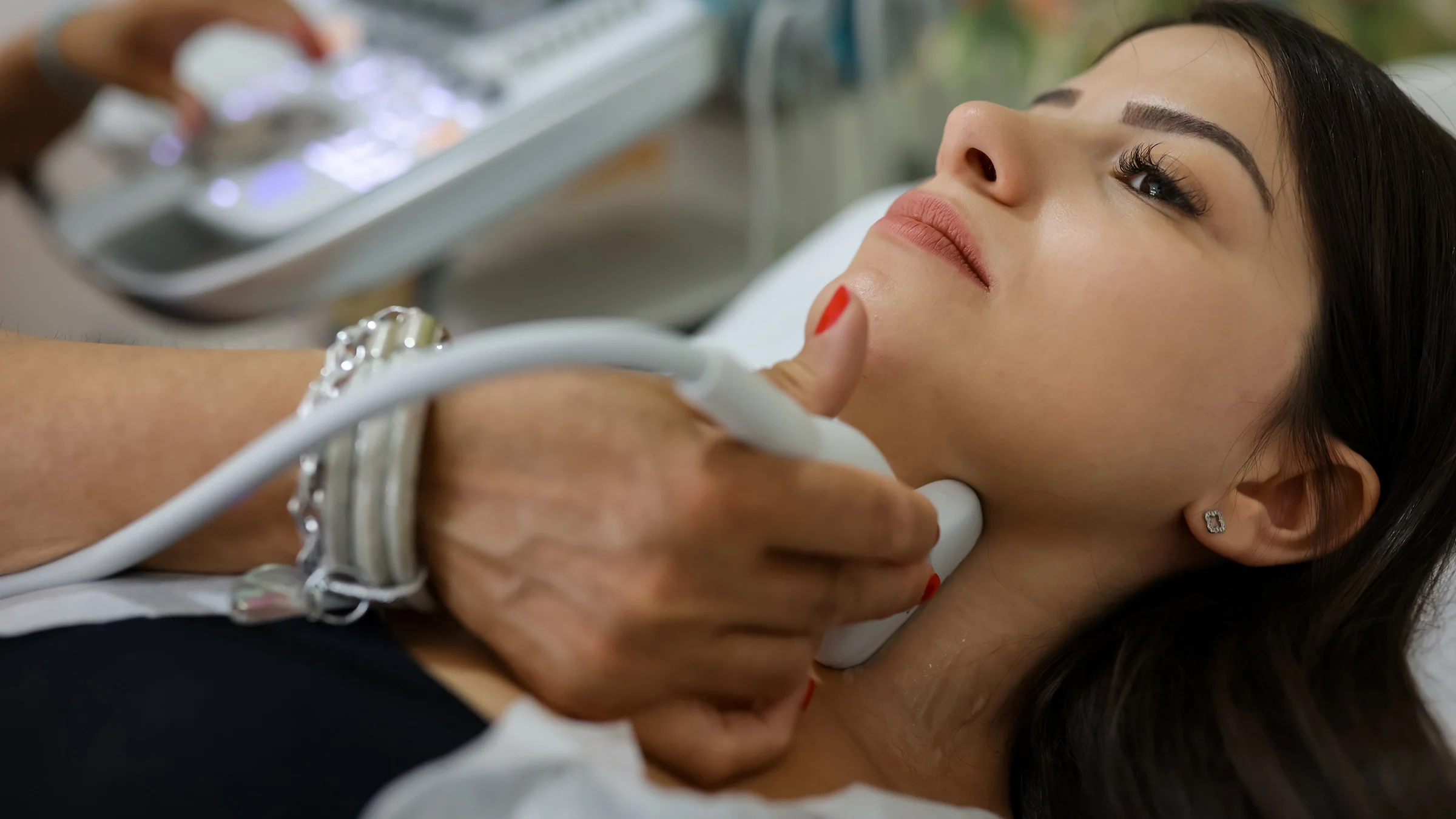 A close-up of a woman receiving an ultrasound on her thyroid.