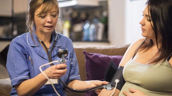Pregnancy: midwife takes blood pressure 467338566