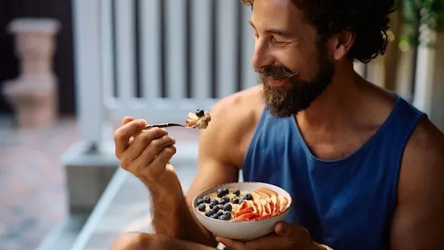 diet-nutrition: man eating oatmeal and fresh fruit 2233714745