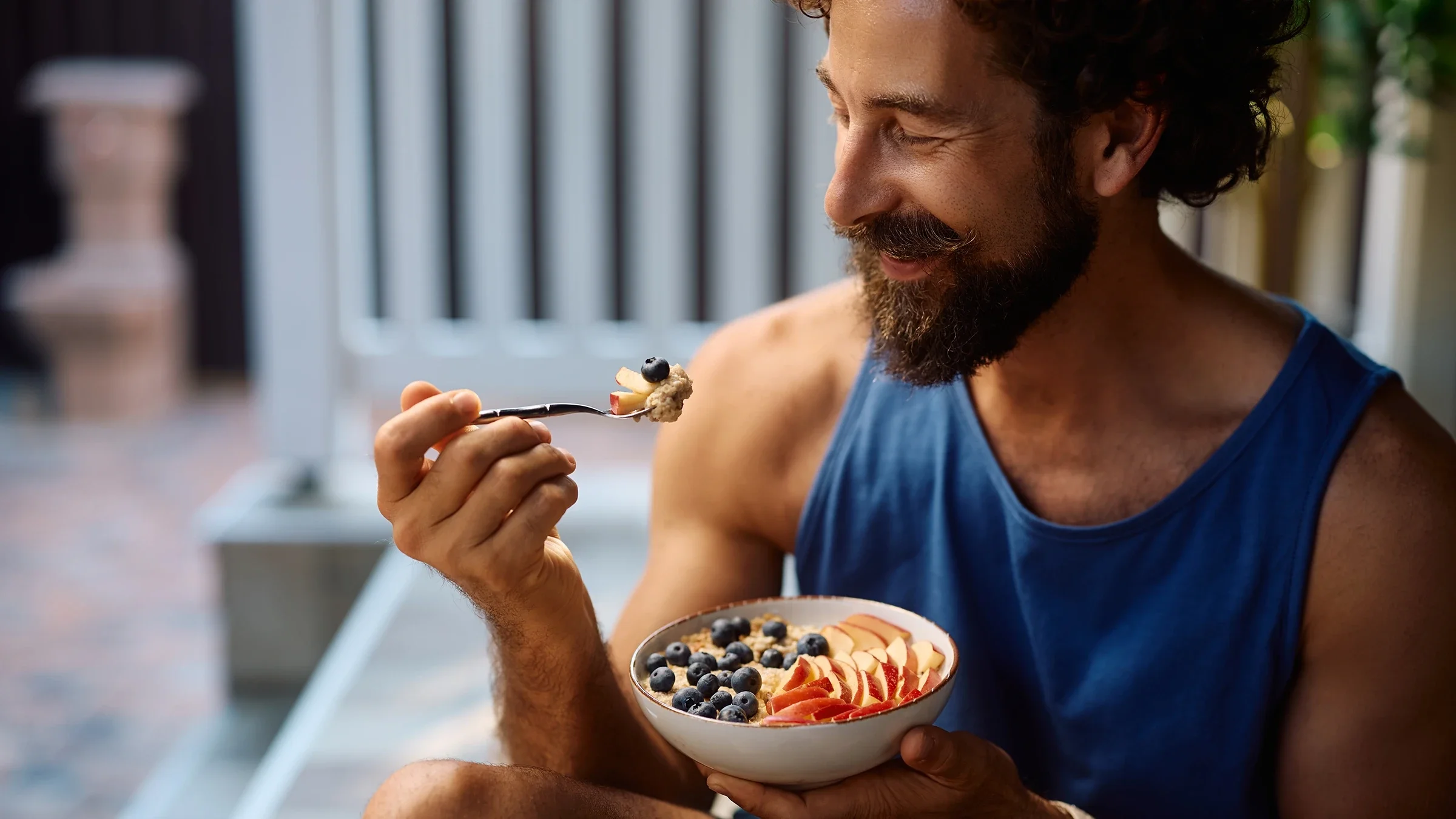 Man eating oatmeal topped with fresh fruit