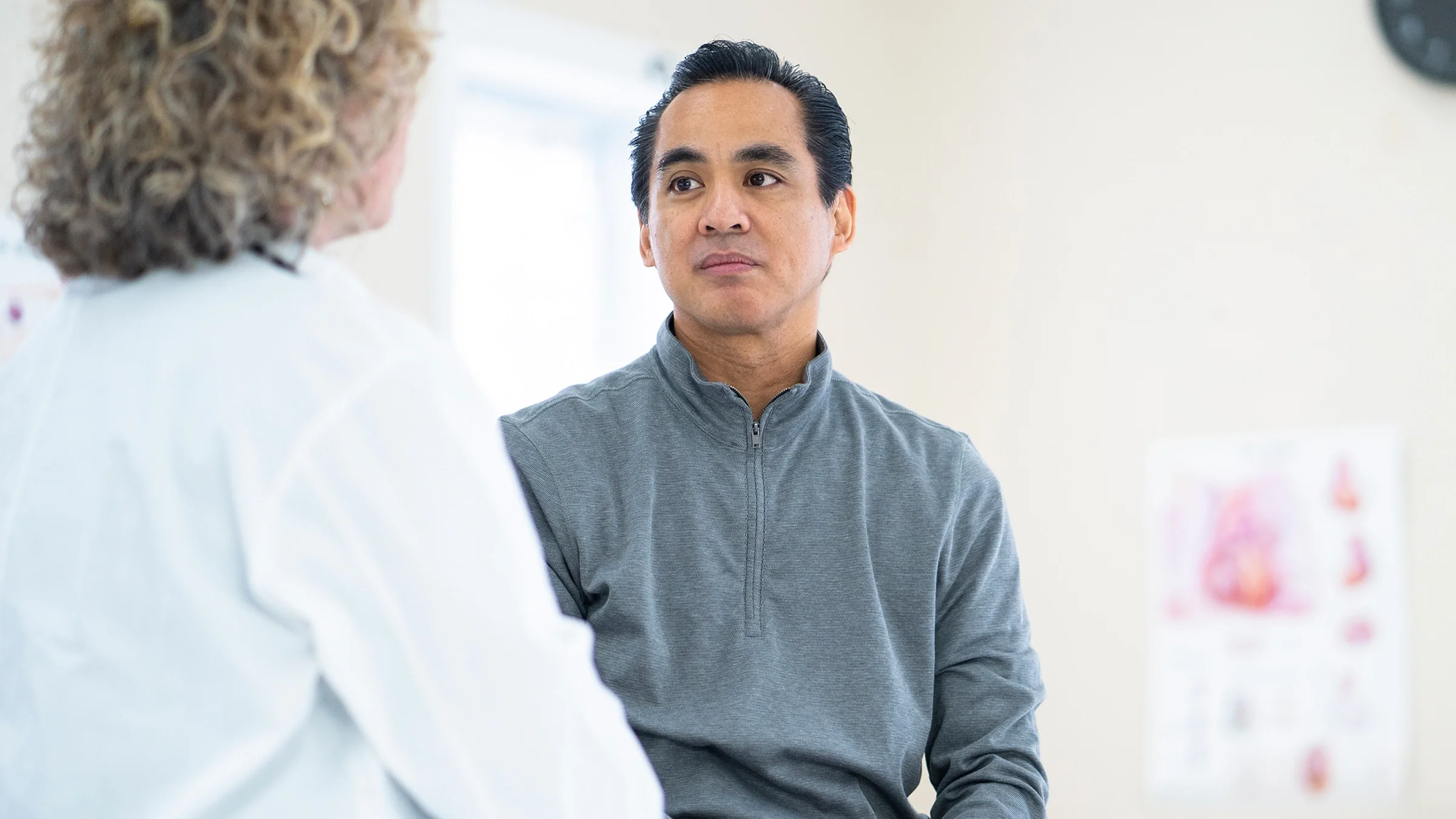 A patient listens to a healthcare professional at a medical appointment.