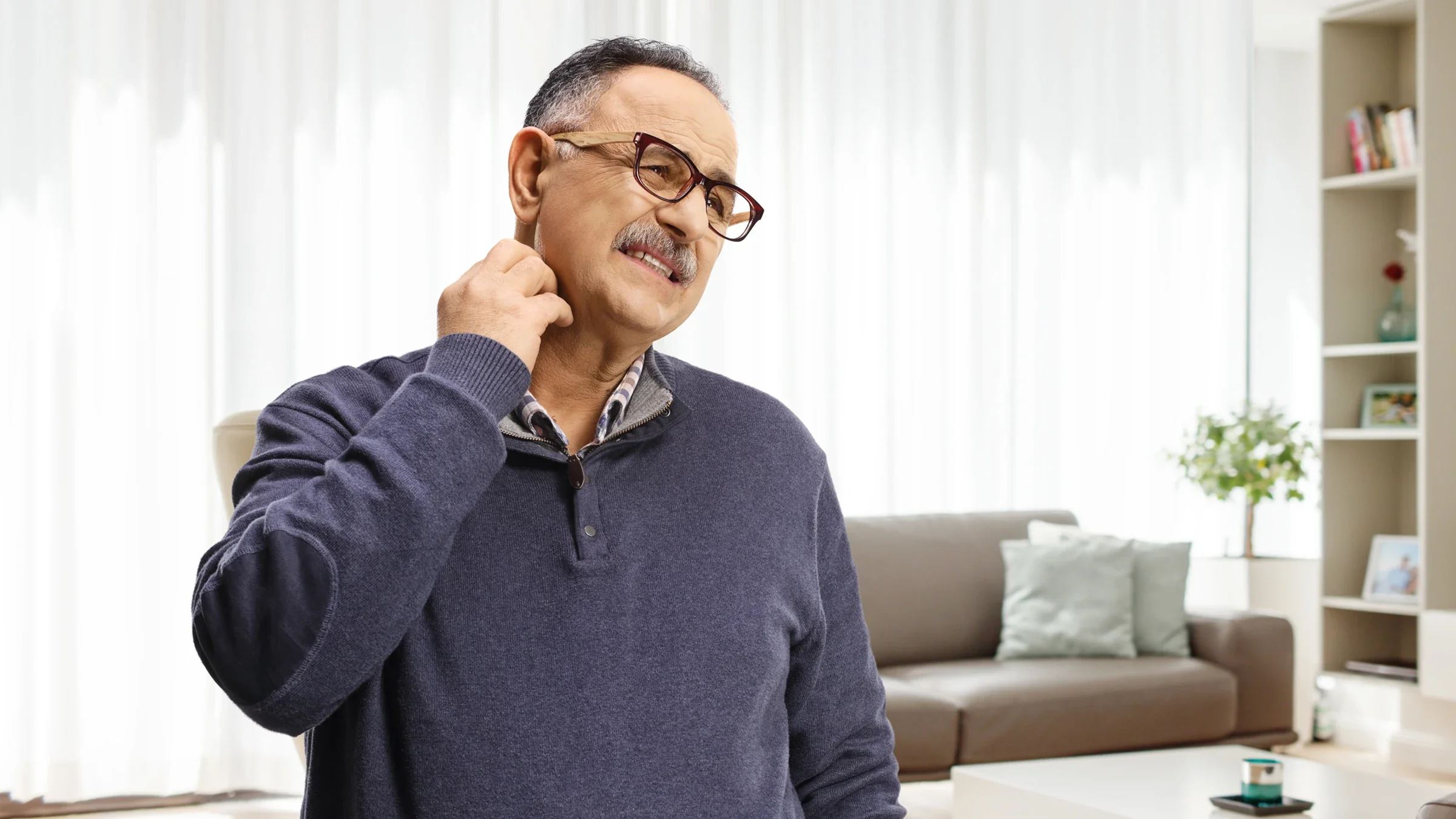 Older man with glasses itching his neck.
Ljupco/iStock via Getty Images