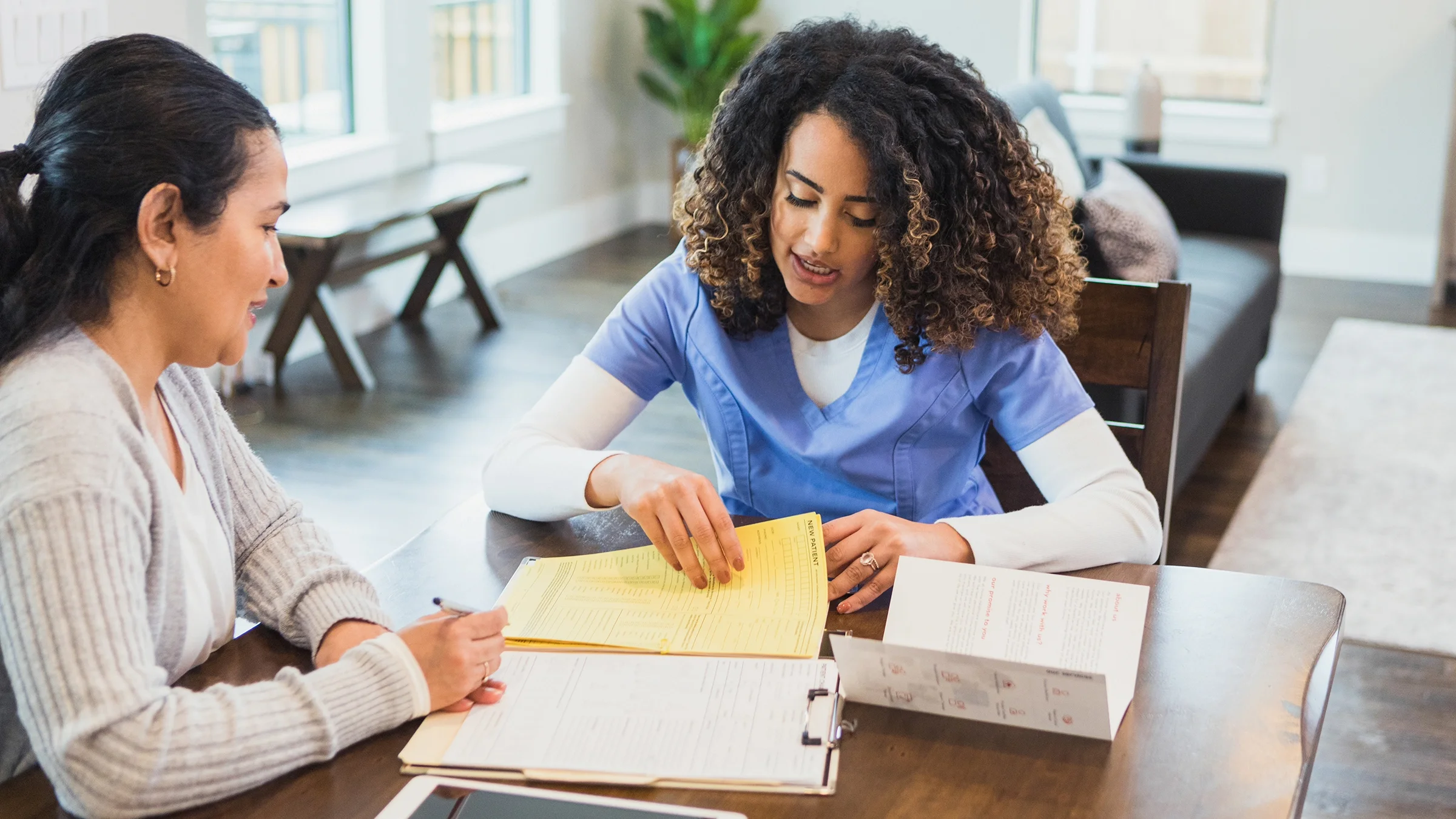 Woman filling out paperwork with nurse.