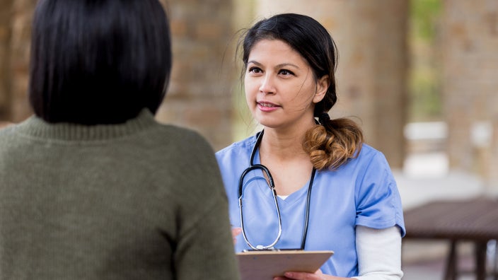 A healthcare professional talking to a patient. 