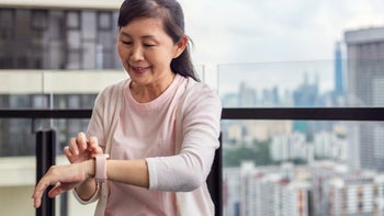 Health: Heart: older woman checking smart watch balcony 1319912846
