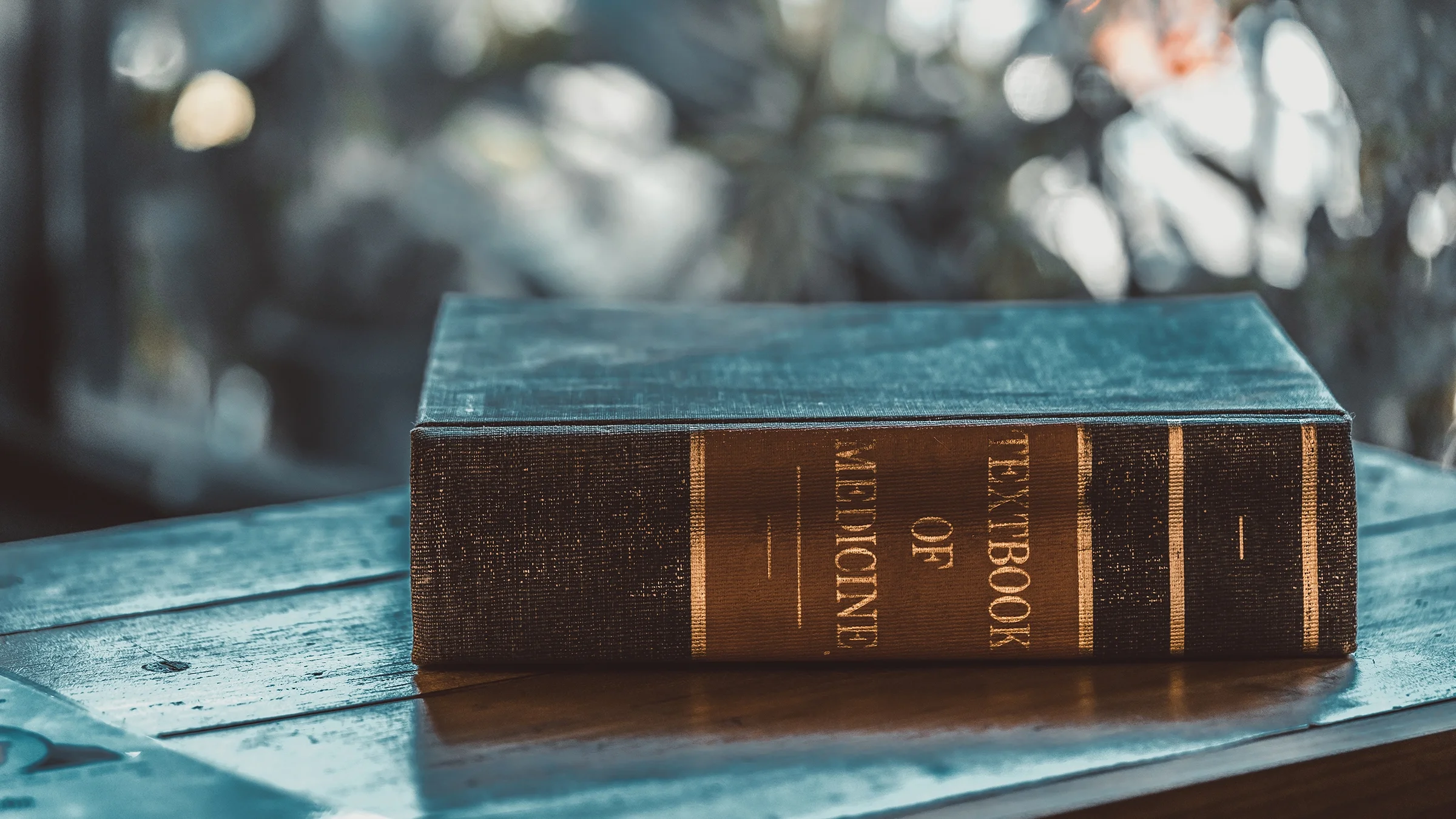 A medical textbook rests on a bench.