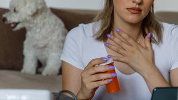 Lamotrigine: telehealth patient with chest pain holding empty pill bottle 1420937454