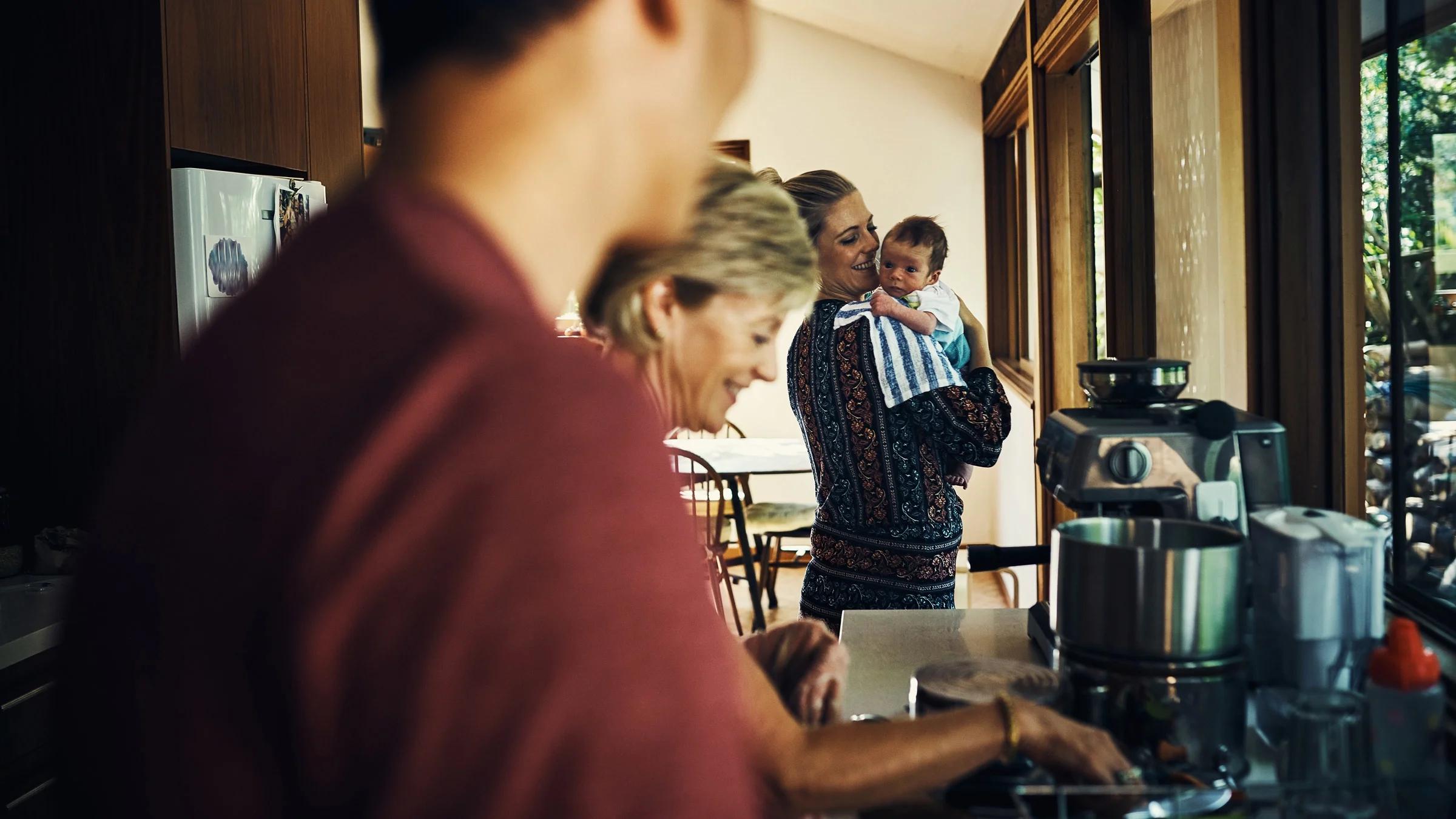 A happy family cooking together. A mother is holding her newborn.