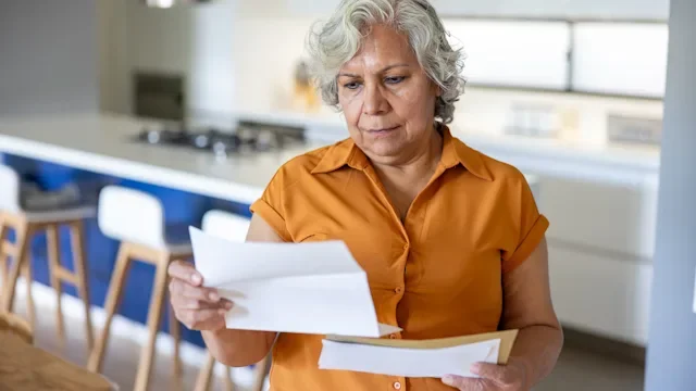 safety: woman looking at paperwork 2202195038