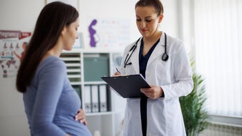 pregnancy: pregnant woman at doctor appointment+1737003385