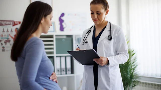 pregnancy: pregnant woman at doctor appointment+1737003385