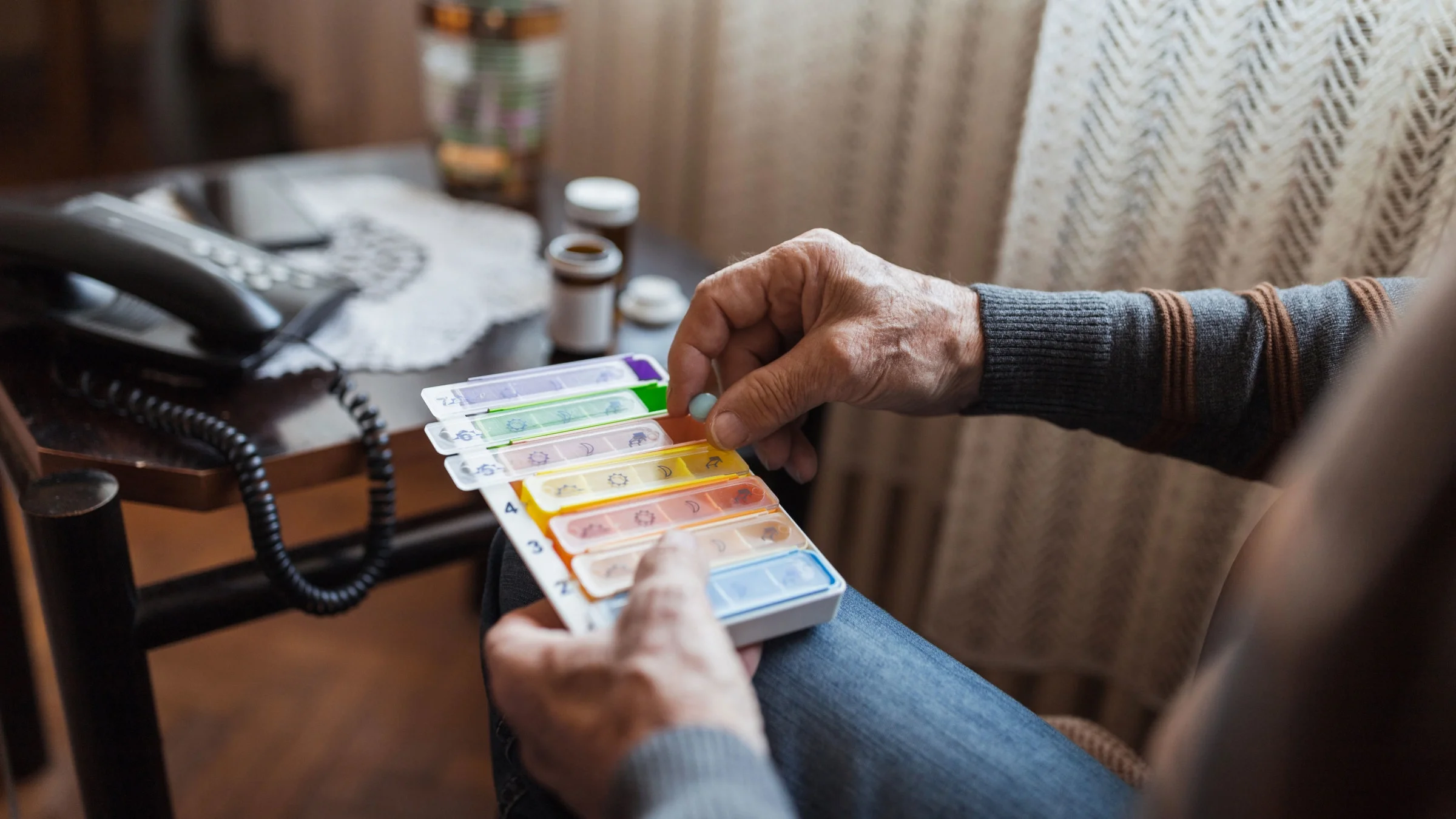 Close up of man with pill organizer. 
