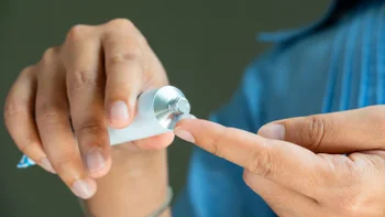 Pharmacy: closeup hands applying ointment 2174074831