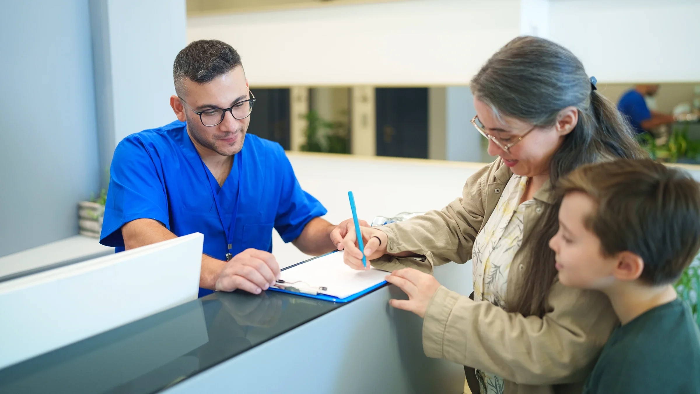 A mother and her child sign in at a medical clinic.