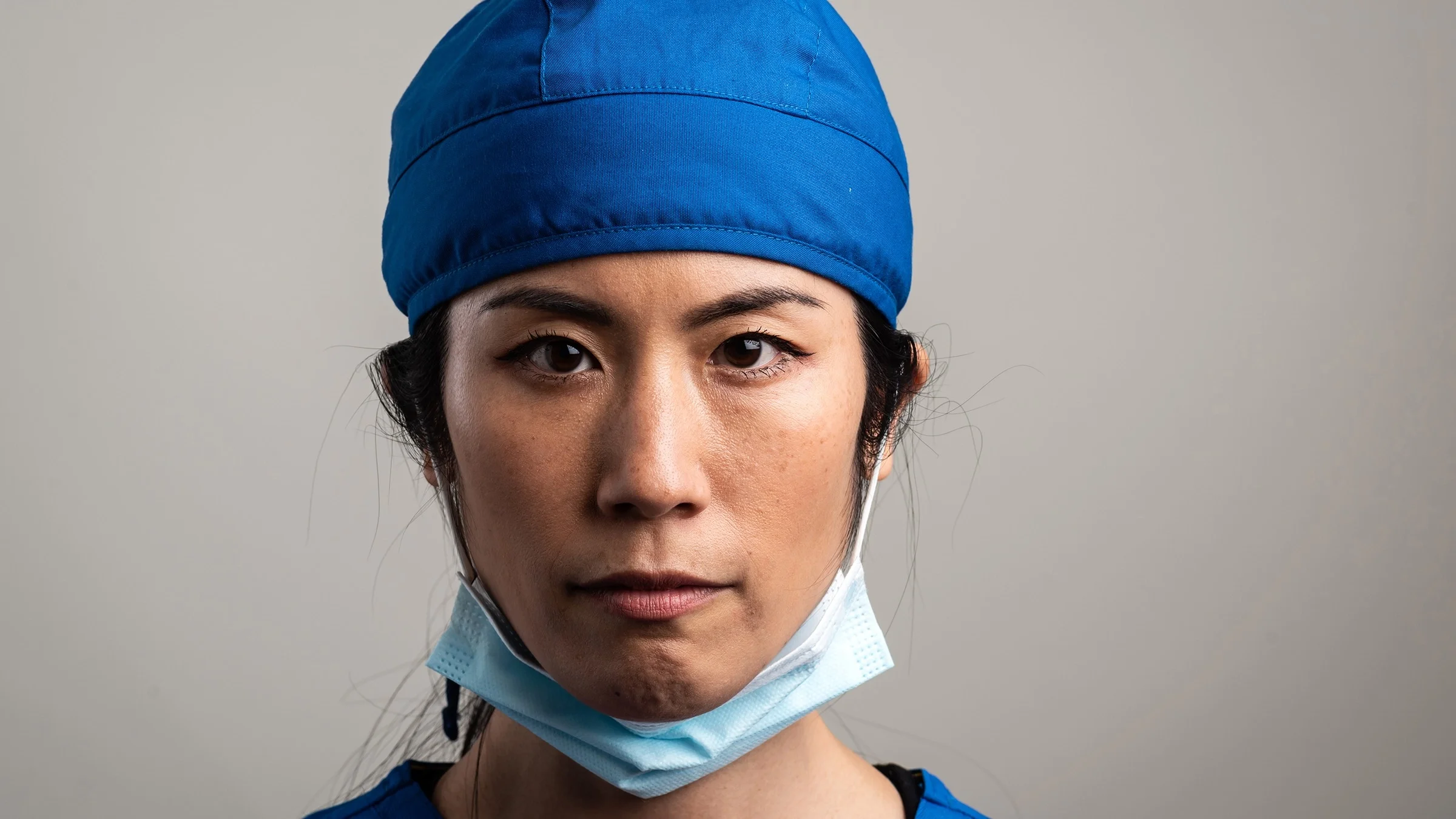 Portrait of a healthcare worker with scrubs and facemask on chin