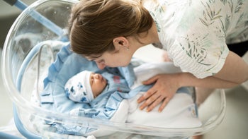 Parenthood pregnancy: Postpartum check-up: mother smiling at baby 1190034139