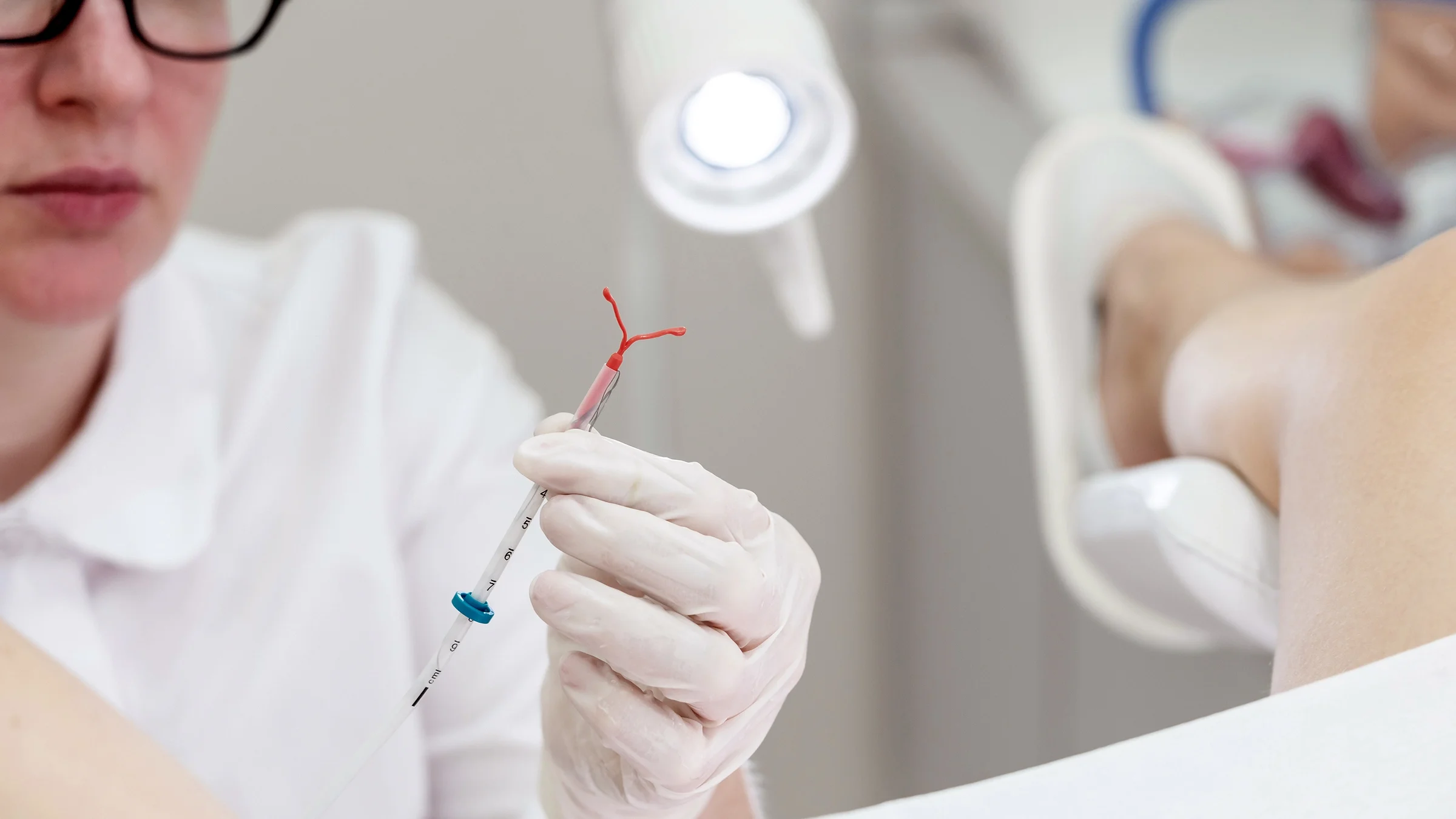 Close-up gynecologist holding an IUD birth control device.