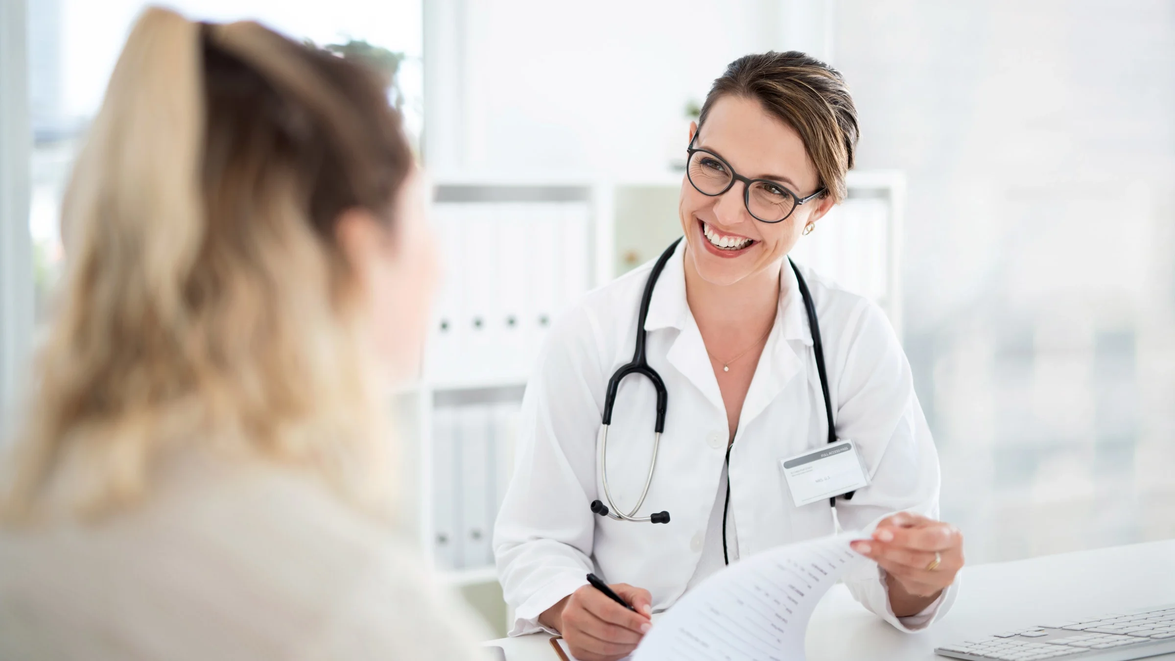 A doctor giving a consultation to an unidentifiable patient.