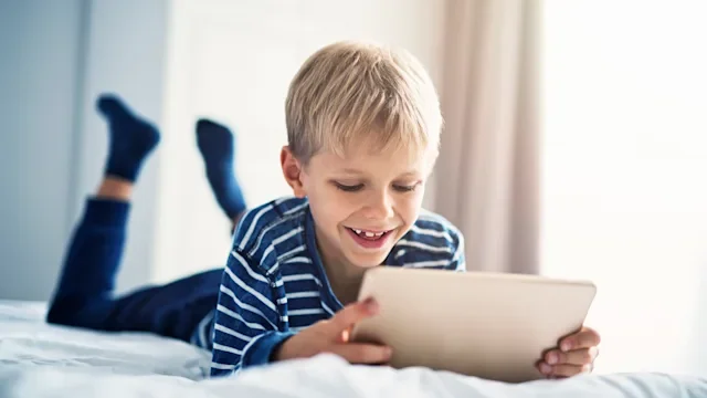 Health: ADHD: blonde child playing games on tablet-862601422