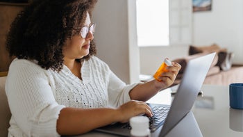 Patient advocacy: Step therapy: holding pill bottle on laptop 1428189640