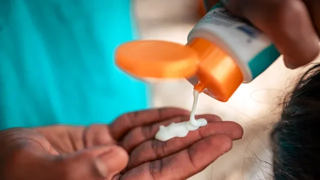 Dermatology: closeup squeezing bottle of sunscreen 2177162920