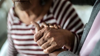 Dementia: Caregiving: closeup caregiver holding senior hand 1397344056