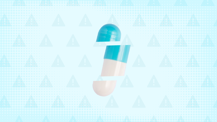 Light teal background with texture and warning sign pattern. In the center is a white and teal capsule pill cut into thirds.  