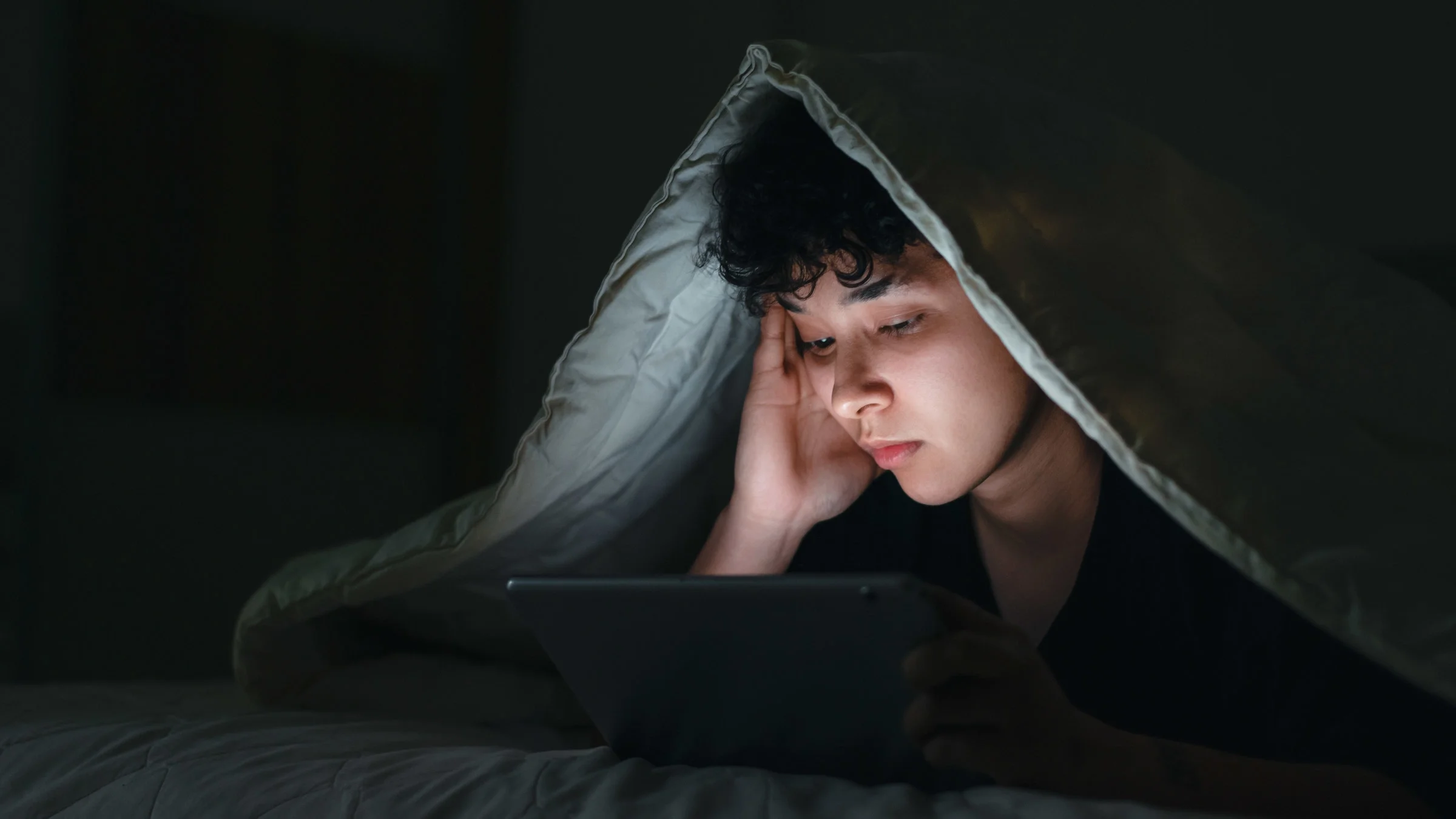 A person watching a movie in bed.