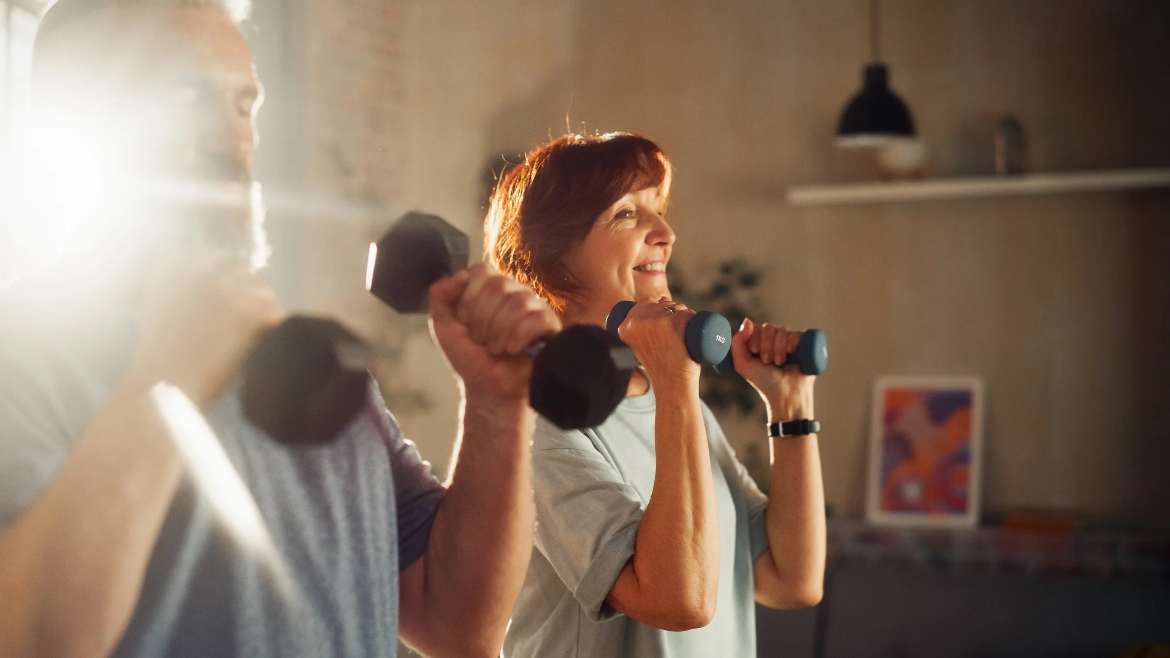 A senior couple exercises with weights.