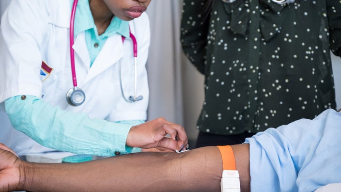 A provider preparing to draw blood.
