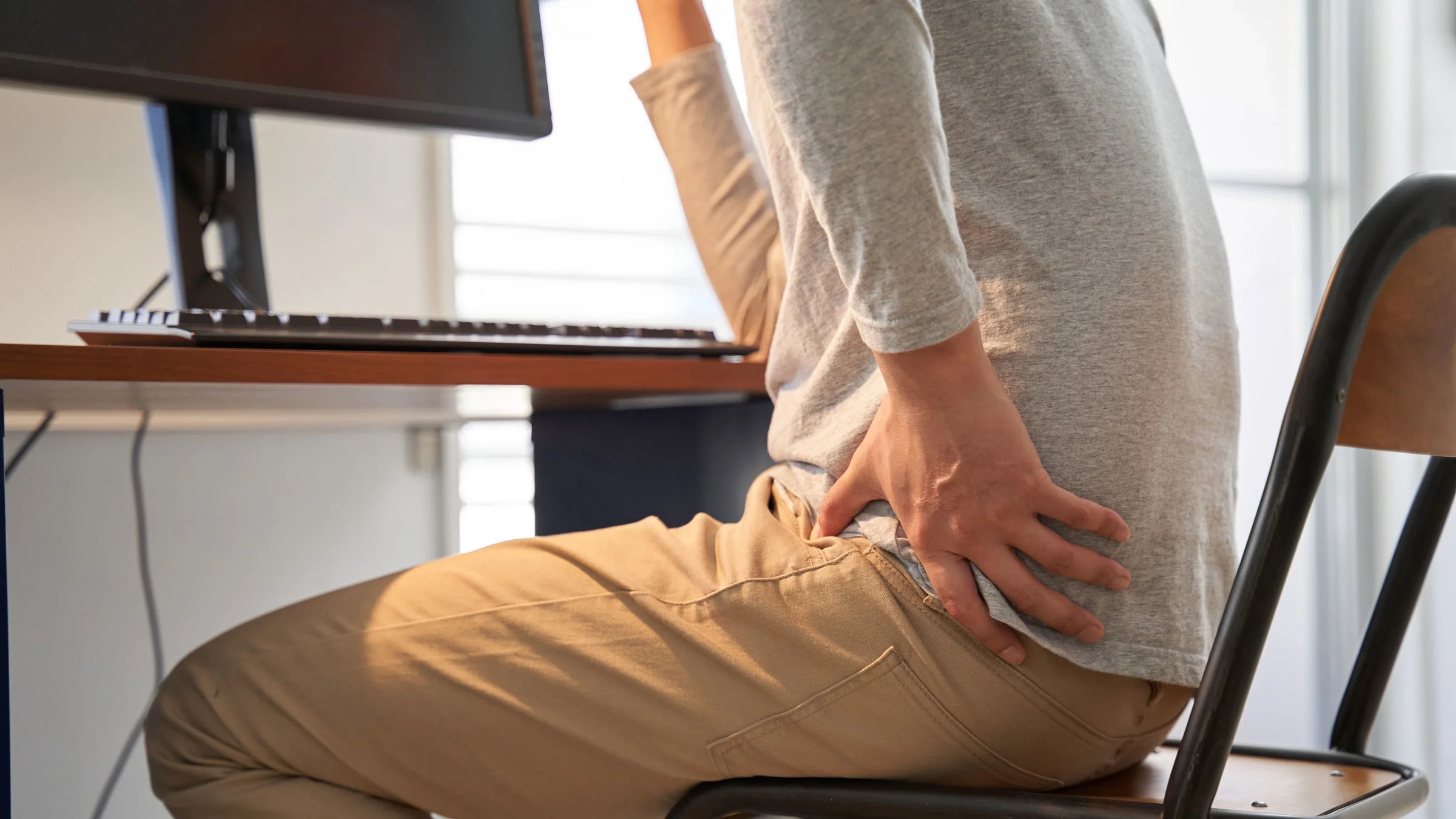 Man with back pain at work desk.