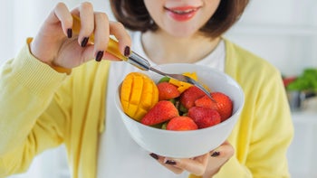 Diet Nutrition: woman eating fruit salad 2201955183